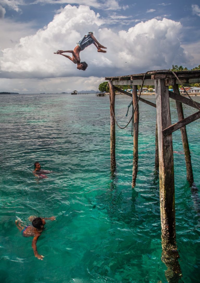 Un enfant sautant d'un ponton dans l'archipel des Raja Ampat