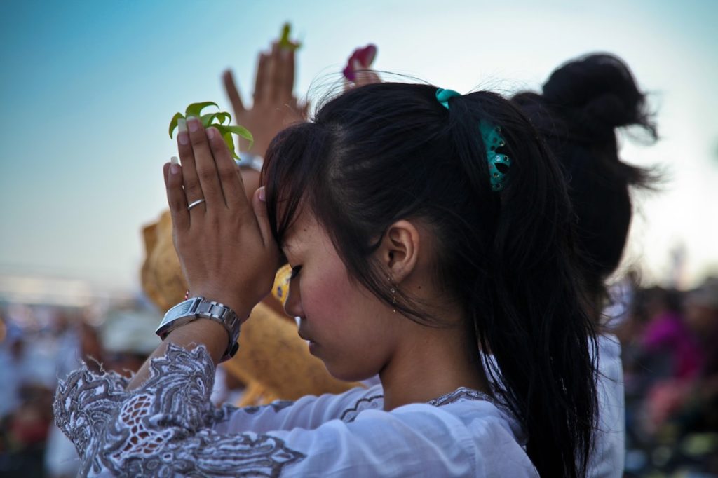 Une jeune femme balinaise priant lors d’une cérémonie