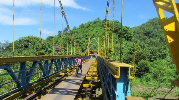 Un homme à vélo sur un pont à Lombok en Indonésie
