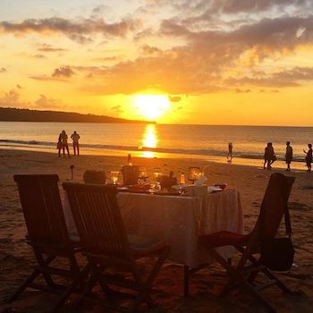 Une table de restaurant romantique sur la plage au coucher du soleil